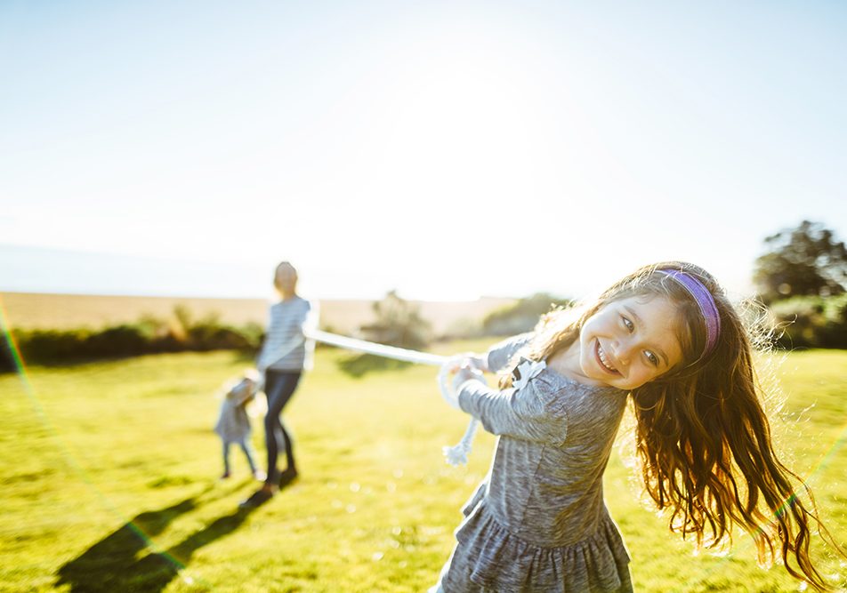 Bambina che gioca insieme alla sua famiglia al parco, conducendo uno stile di vita sano e attivo come forma di prevenzione contro lo streptococco