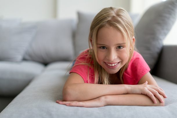 bambina-gioiosa-sul-divano-di-casa-guarigione-da-infiammazione-del-palato Bambina gioiosa sul divano di casa guarita dall’infiammazione del palato