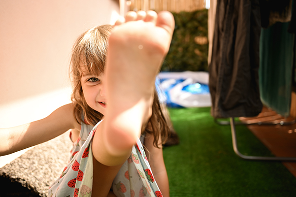 Bambina gioiosa nel cortile di casa, senza più dolori a gambe e caviglie causati dallo streptococco
