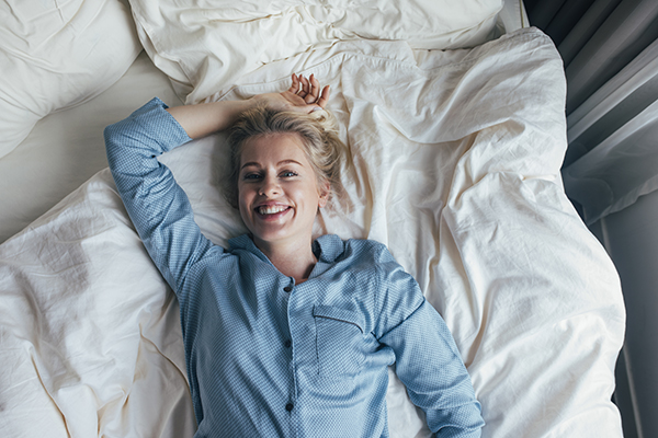 Donna sul letto di casa che evita il contagio da scarlattina mantenendo sane abitudini e un riposo adeguato