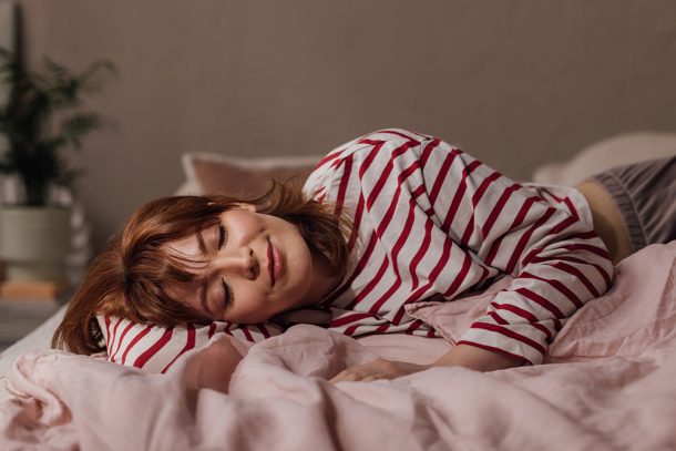 donna-con-disturbi-del-sonno-riposando-a-letto Giovane donna dai capelli rossi che soffre di disturbi del sonno e cerca di riposare a letto in un ambiente rilassante