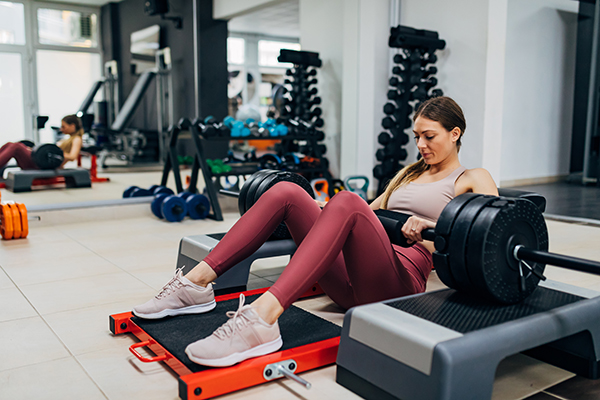 Donna che esegue una serie di hip thrust in palestra durante il suo allenamento quotidiano