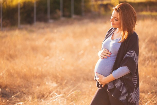 Donna in gravidanza con esenzione M50 rilassata nella natura mentre aspetta la nascita del suo piccolo