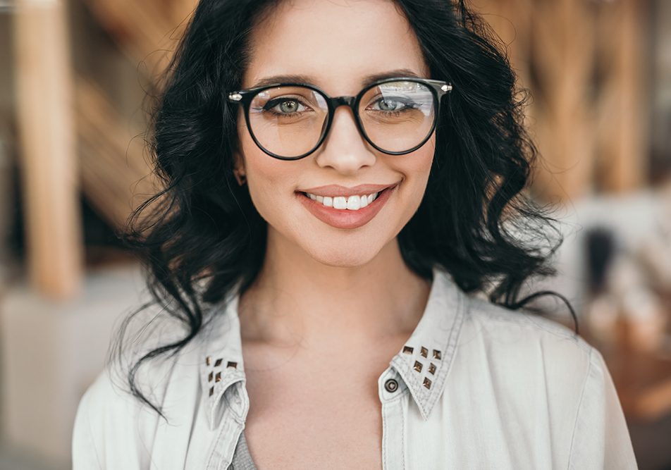 Donna che indossa occhiali da vista valuta la possibilità di sottoporsi all’operazione agli occhi per la cura della miopia