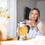 Donna che sorseggia un infuso alla camomilla, un rimedio della nonna contro il reflusso gastroesofageo