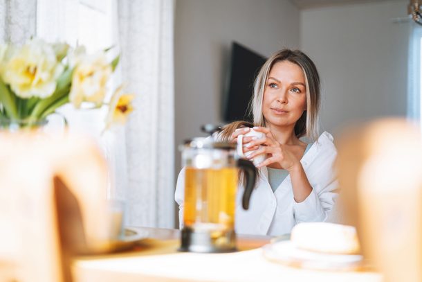 Donna che sorseggia un infuso alla camomilla, un rimedio della nonna contro il reflusso gastroesofageo