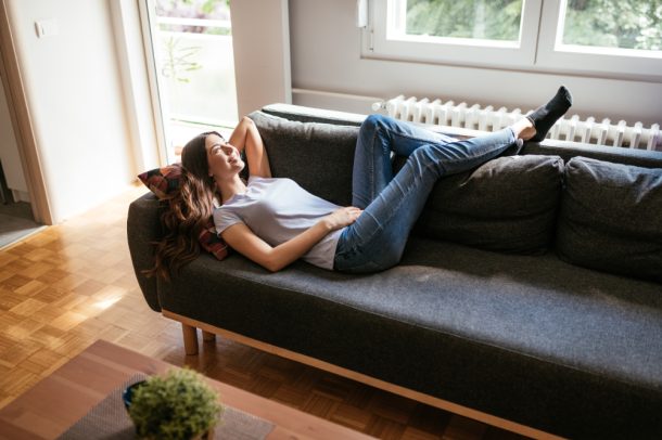 Giovane donna stesa sul divano che presenta sintomi di ematuria