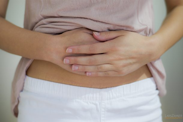 Donna che si tocca la pancia dopo avere avvertito dolore alla bocca dello stomaco