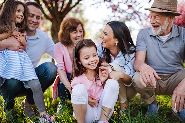 Famiglia intergenerazionale al parco che previene lo streptococco mantenendo in salute il sistema immunitario