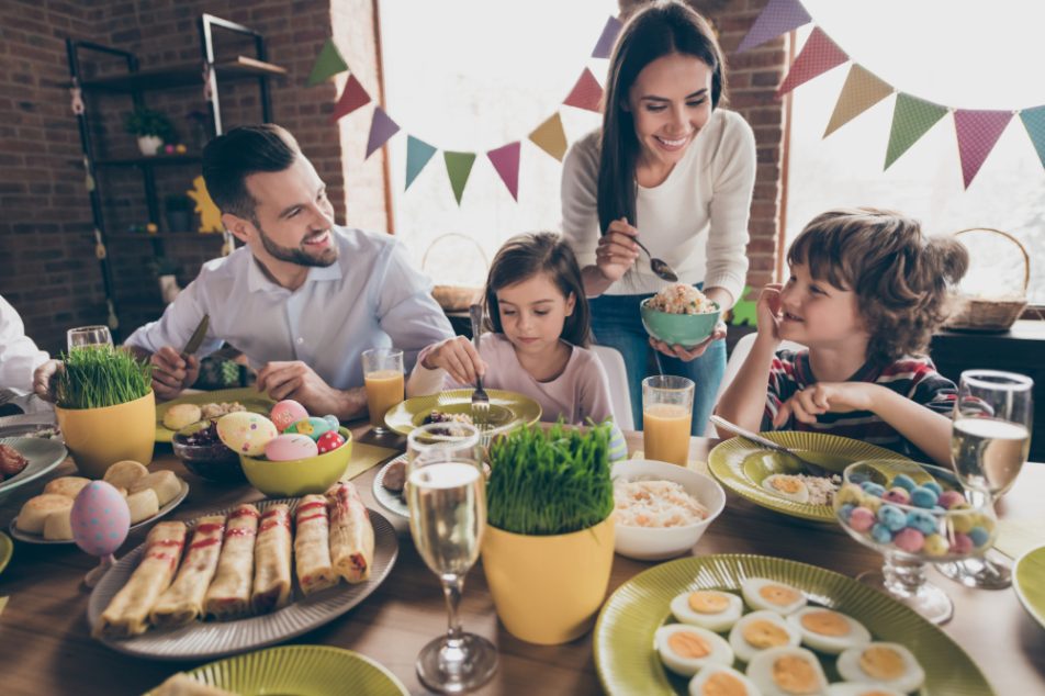 famiglia-gusta-alimentazione-sana-a-pasqua Famiglia a tavola il giorno di Pasqua si gode la festa con un'alimentazione sana