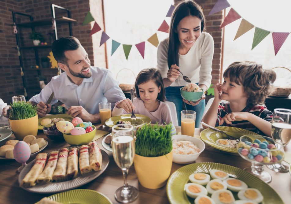 famiglia-gusta-alimentazione-sana-a-pasqua Famiglia a tavola il giorno di Pasqua si gode la festa con un'alimentazione sana