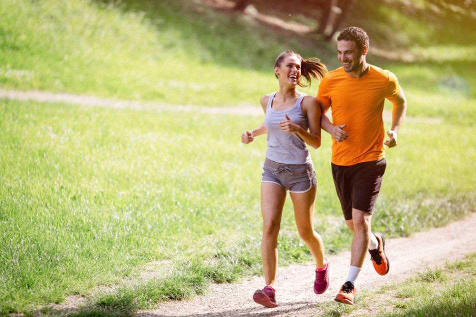 Una giovane coppia che corre al parco potrebbe soffrire di crampi ai muscoli