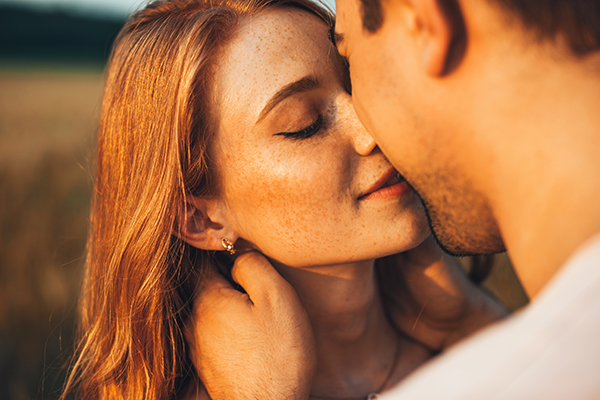 Giovane donna che bacia un uomo a rischio di contagio dell’herpes labiale