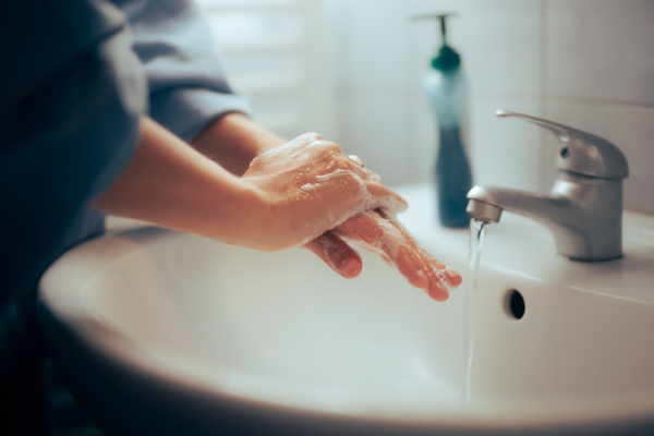 Adulto si lava le mani per prevenire la scarlattina