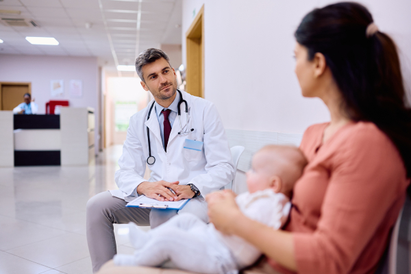 Dottore monitora madre e neonato dopo la procedura di un parto a ventosa