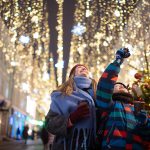 Madre e figlio che si divertono visitando un mercatino di Natale in seguito ad una ricerca su dove andare a Natale in Italia