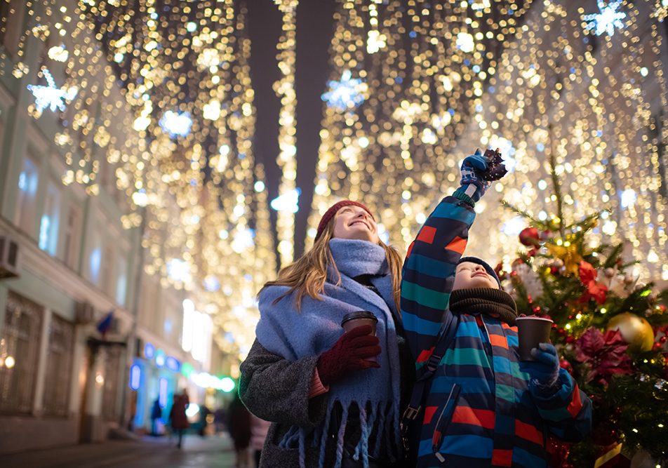 madre-e-figlio-visitando-mercatino-natalizio-dopo-ricerca-su-dove-andare-a-natale-in-Italia Madre e figlio che si divertono visitando un mercatino di Natale in seguito ad una ricerca su dove andare a Natale in Italia