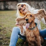 Padrona felice al parco insieme al suo cane, in cura per l’otite con Augmentin