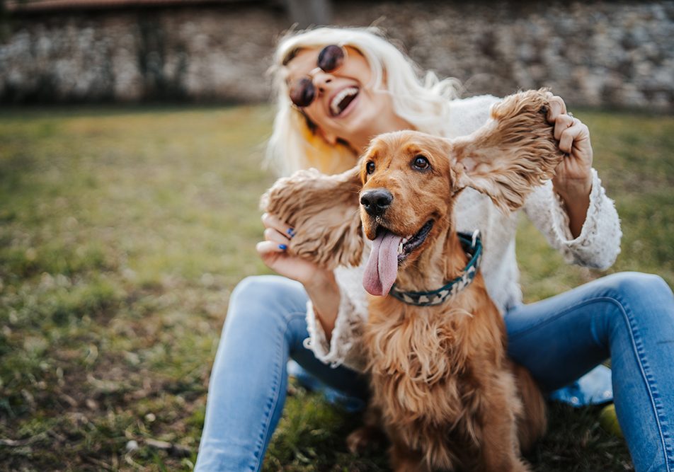 Padrona felice al parco insieme al suo cane, in cura per l’otite con Augmentin