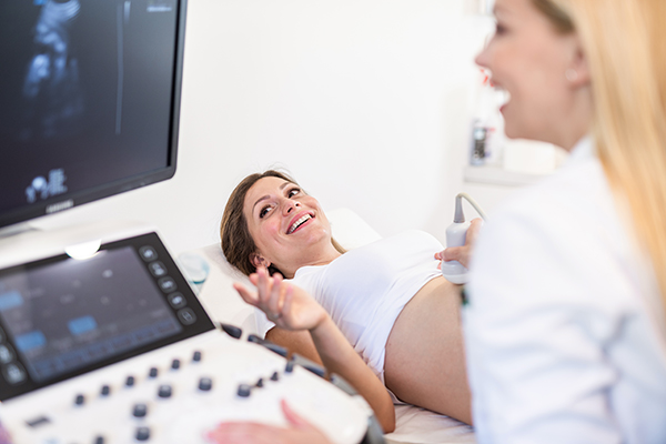 Giovane paziente durante un’ecografia ostetrica, uno degli esami esenti in gravidanza di settimana in settimana eseguibili in ASL