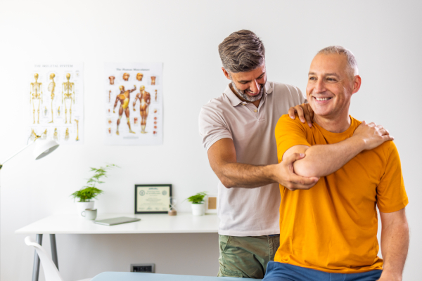 Paziente che svolge fisioterapia per il recupero di braccia e spalle con la supervisione del fisioterapista