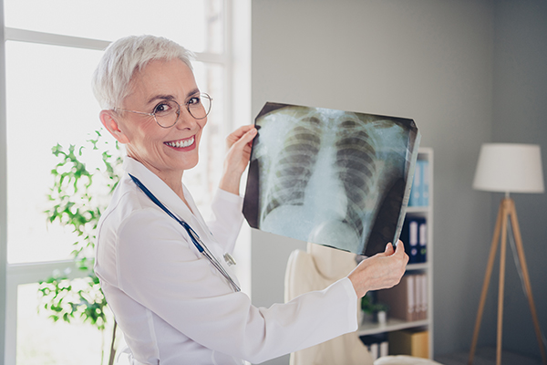 Modico radiologo che esamina una radiografia del torace per verificare l’ insorgenza dello pneumotorace