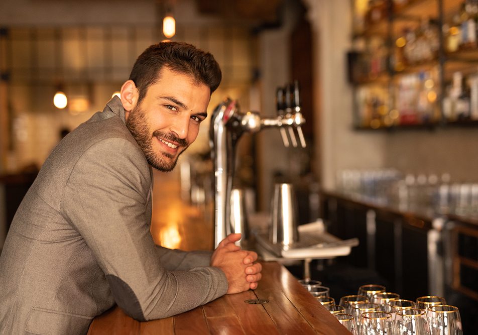 Uomo che domanda una birra al bancone del locale e si interroga sugli effetti collaterali di Augmentin e alcol