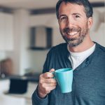 Uomo di mezza età che combatte i sintomi da helicobacter pylori adottando rimedi naturali e mantenendo salubre l’ambiente casalingo