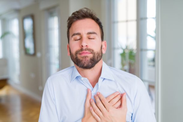 Giovane uomo che soffre di versamento pleurico si tocca il petto