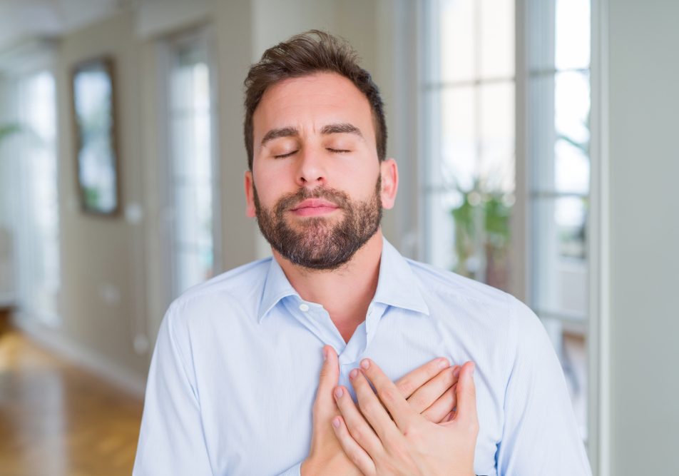 Giovane uomo che soffre di versamento pleurico si tocca il petto