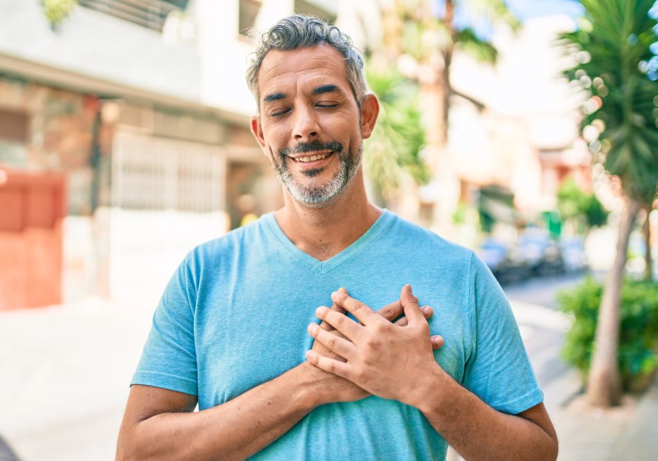 Uomo maturo sorride toccandosi il petto dopo intervento stenosi aortica