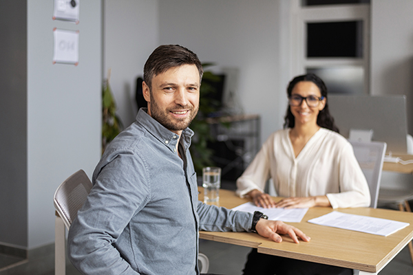 Utente che domanda a segretaria ASL informazioni sulla pratica di richiesta esenzione ticket