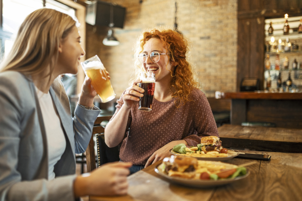 Amiche mangiano cibi fritti e bevono alcol, da evitare per chi soffre di reflusso esofageo