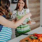 Amiche in cucina che indossano il grembiule e preparano una ricetta ricca di Omega 3 con tonno e semi di lino