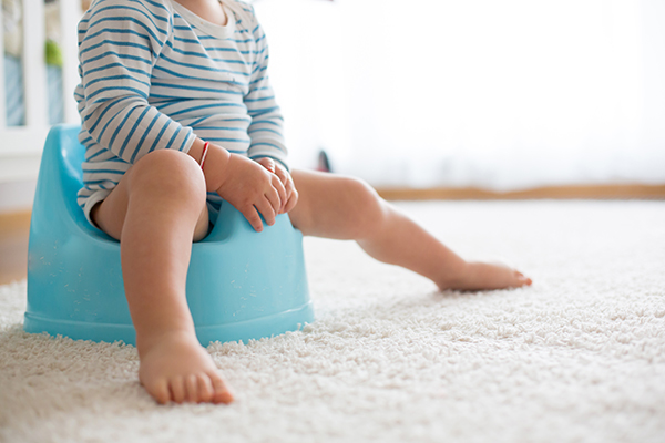 Bambino che, mentre si allena all’utilizzo del vasino, fa la cacca di colore verde