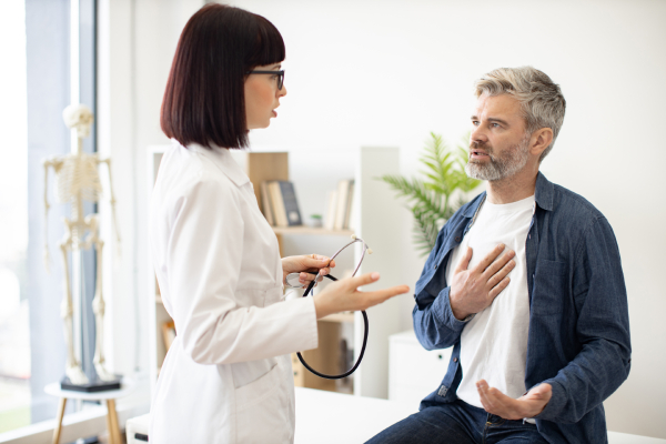 Uomo che parla con il medico per dolore al petto