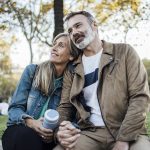 Coppia matura affiatata affetta dal cancro al pancreas che si gode un’uscita al parco e sosta su una panchina