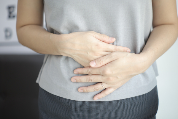 Donna con dolore addominali, tra i primi sintomi del tumore al pancreas