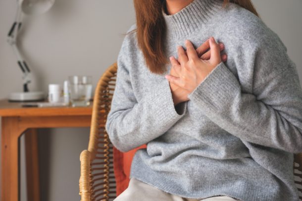 Donna con insufficienza cardiaca si tocca il petto per sintomo angina pectoris