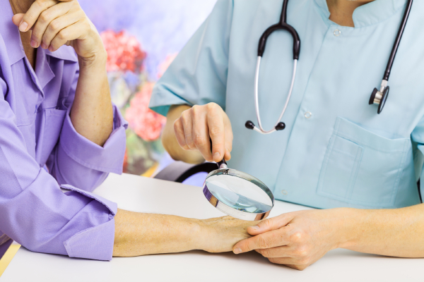 Dermatologo controlla le mani di una donna con prurito alle mani
