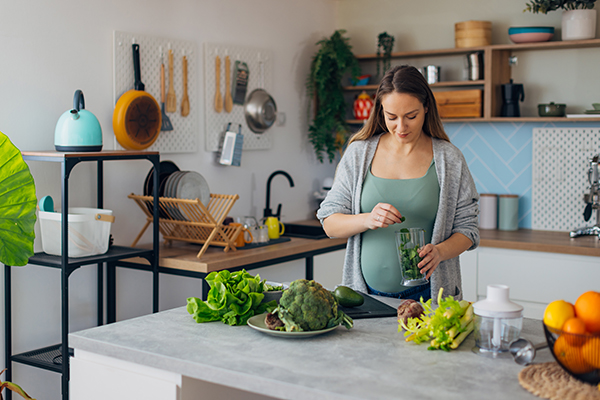 Donna in gravidanza che segue un’alimentazione sana a base di verdure come uno dei rimedi per le gengive gonfie