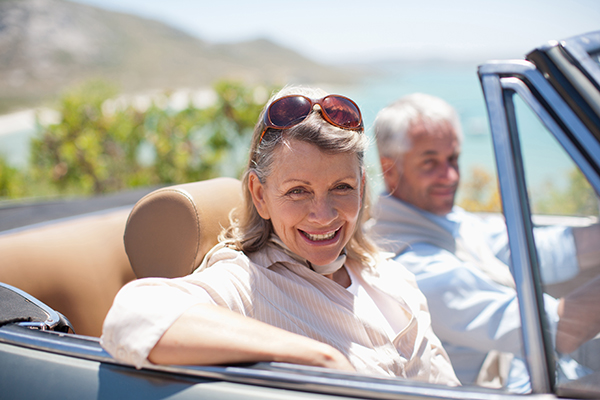 Donna senior con tumore al pancreas che fa un giro in cabriolet lungo la costa insieme al marito, per mantenere uno stile di vita sano