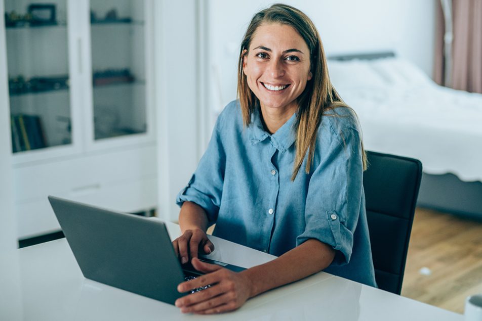 Donna che utilizza il computer a casa per sporgere richiesta dell’esenzione ticket online