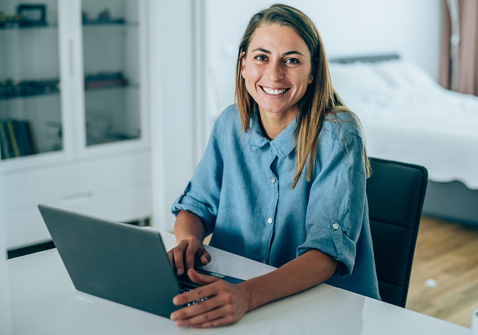 Donna che utilizza il computer a casa per sporgere richiesta dell’esenzione ticket online