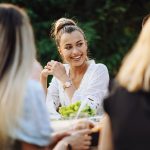 Giovane donna che soffre di pancreatite che si gode un pranzo insieme alle amiche all’aria aperta