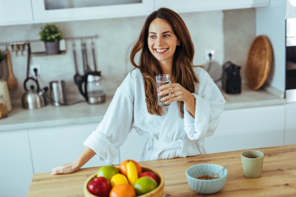 Giovane donna si idrata, tra i rimedi per il reflusso
