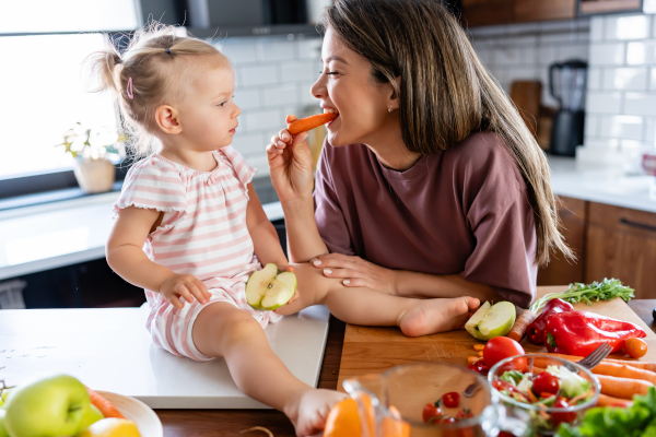 Giovane madre con il proprio bambino, mangia verdure per gestire la prolattina alta