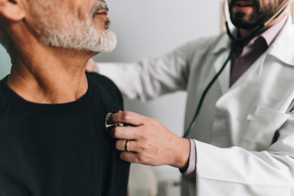 Medico visita paziente e gli fornisce indicazioni dopo intervento angioplastica