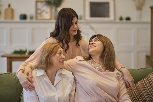 Nonna, madre e figlia a casa che si abbracciano calorosamente dopo l’avvenuto trapianto della donna anziana