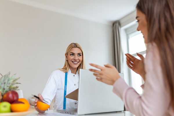 Nutrizionista nel suo studio che informa la paziente sul corretto apporto di Omega 3 e di Omega 6 nella dieta